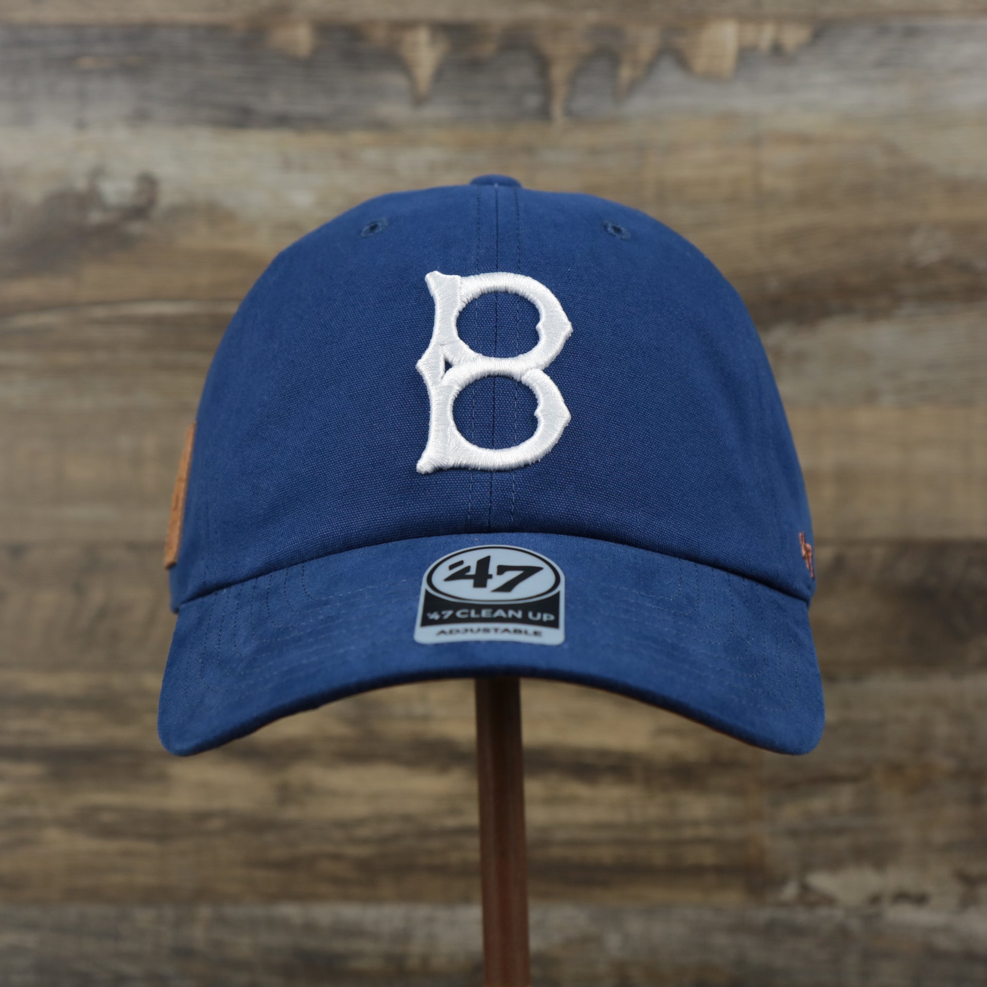 The front of the Cooperstown Brooklyn Dodgers Cooperstown Collection Side Patch Leather Brown Undervisor Dad Hat | Vintage Royal Blue Dad Hat