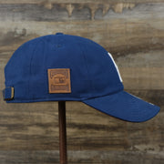 The wearer's right on the Cooperstown Brooklyn Dodgers Cooperstown Collection Side Patch Leather Brown Undervisor Dad Hat | Vintage Royal Blue Dad Hat