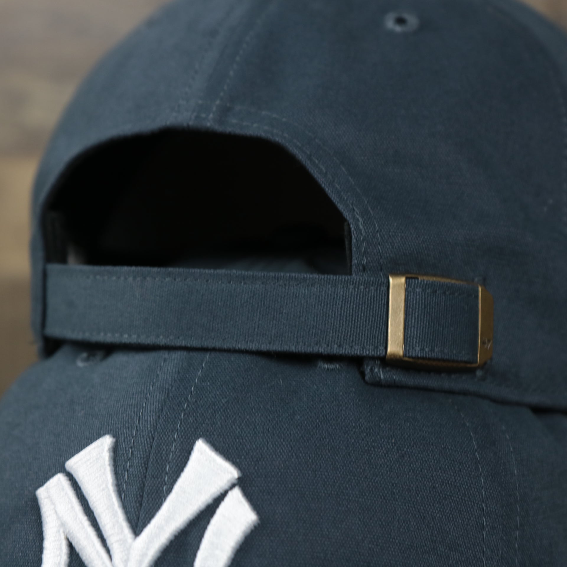 The Navy Adjustable Strap on the Cooperstown New York Yankees Cooperstown Collection Side Patch Leather Brown Undervisor Dad Hat | Vintage Navy Dad Hat