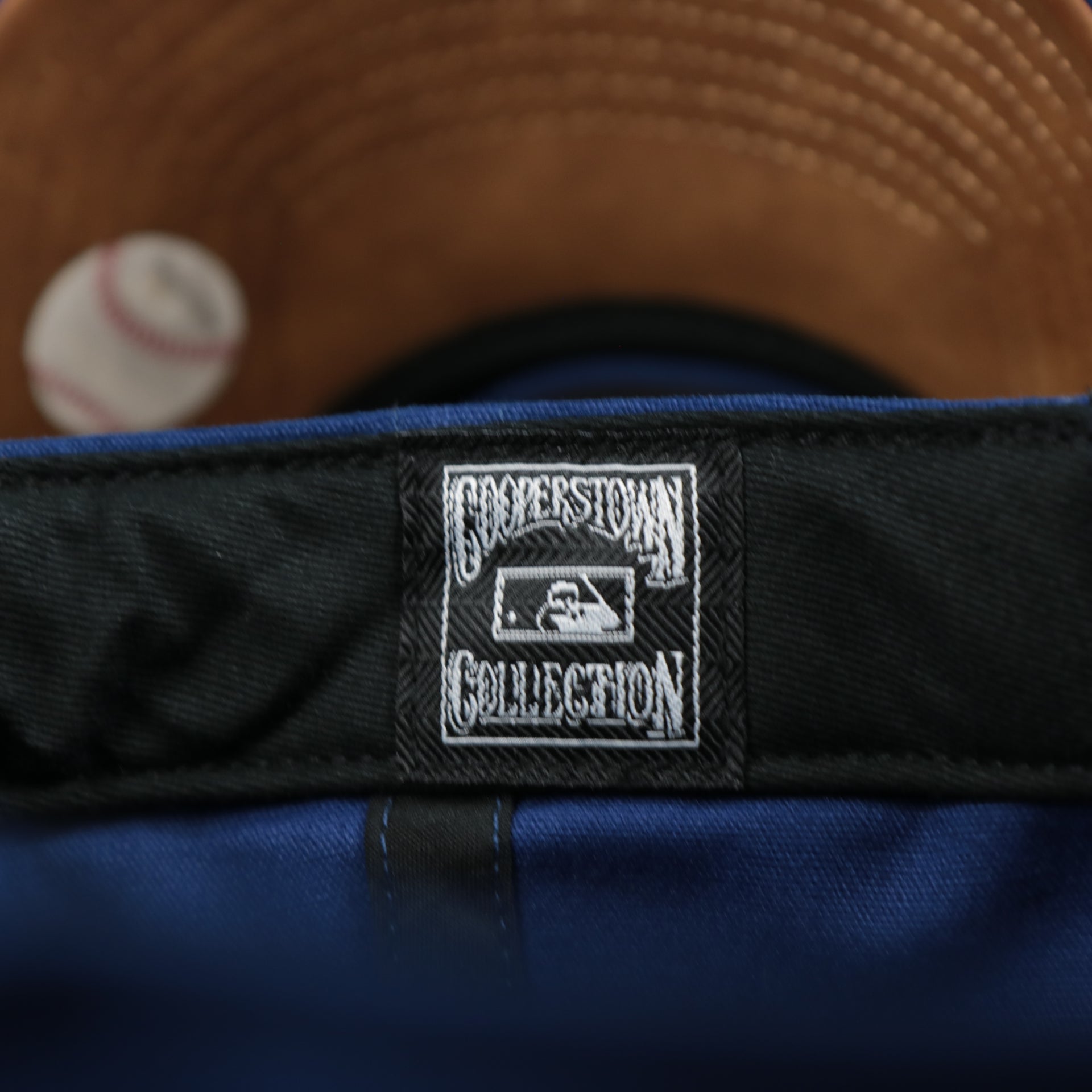 The Cooperstown Collection Tag on the Cooperstown Brooklyn Dodgers Cooperstown Collection Side Patch Leather Brown Undervisor Dad Hat | Vintage Royal Blue Dad Hat
