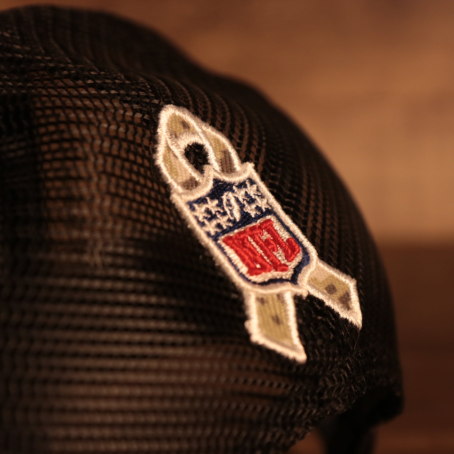 Close up of the NFL Salute To Service Ribbon on the Tampa Bay Buccaneers 2021 Salute To Service On Field Sideline 9Fifty Snapback Trucker Hat