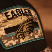 Close up of the Eagles patch on the front of the Philadelphia Eagles 2021 Salute To Service On Field Sideline 39Thirty Stretch Fit Hat