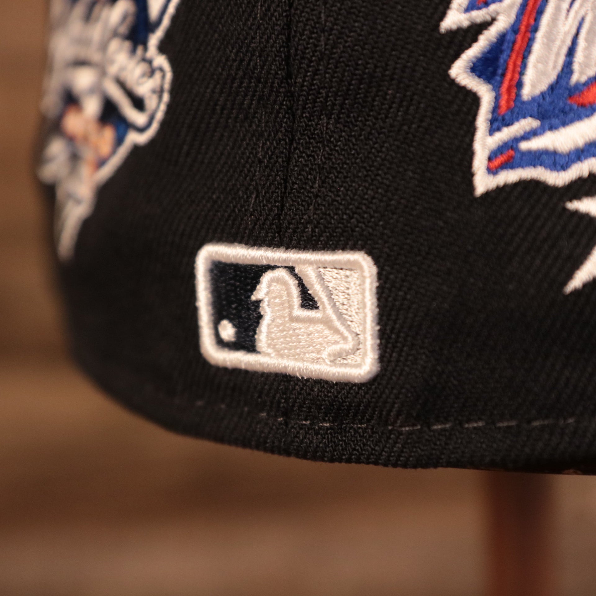 Close up shot of the MLB Batterman logo embroidered in white and navy blue on the back of the 59Fifty New York Yankees All Over World Series Side Patch Fitted Cap
