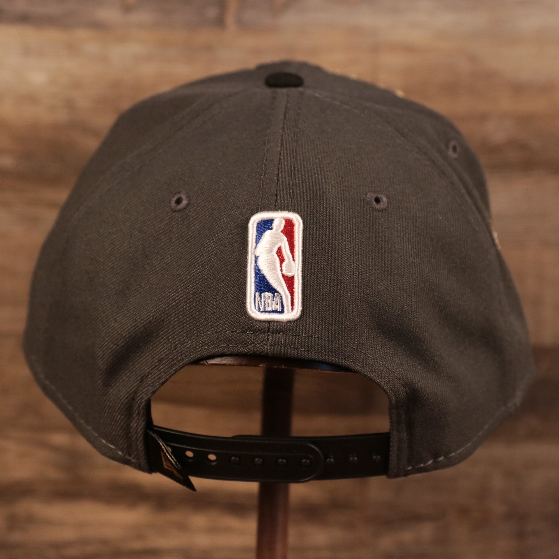 The back of the 2021 NBA Champions Milwaukee Bucks snapback hat which features the Jerry West silhouette NBA logo above an adjustable snap