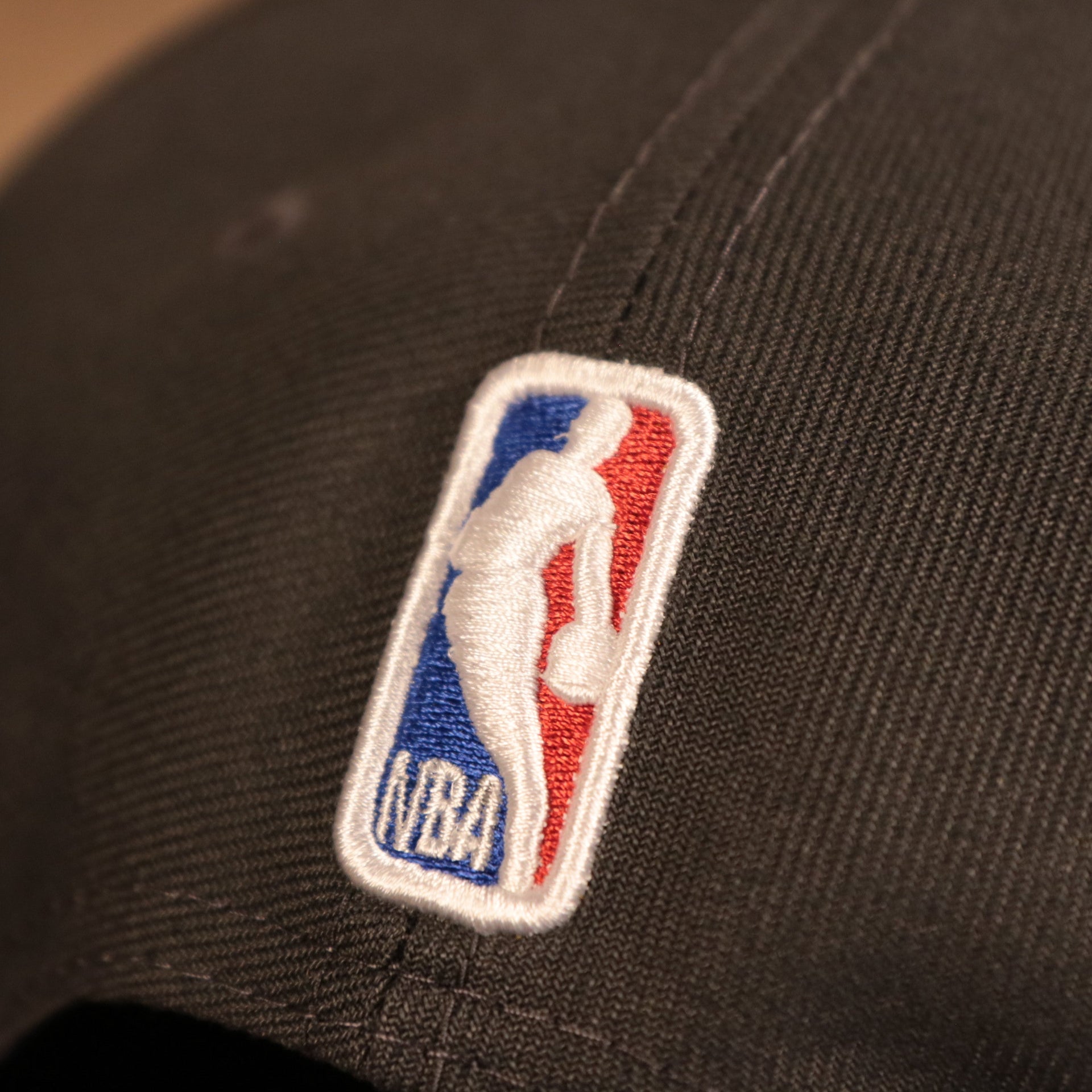 A close up of the NBA logo embroidered on the 2021 Milwaukee Bucks NBA Champions snapback aht