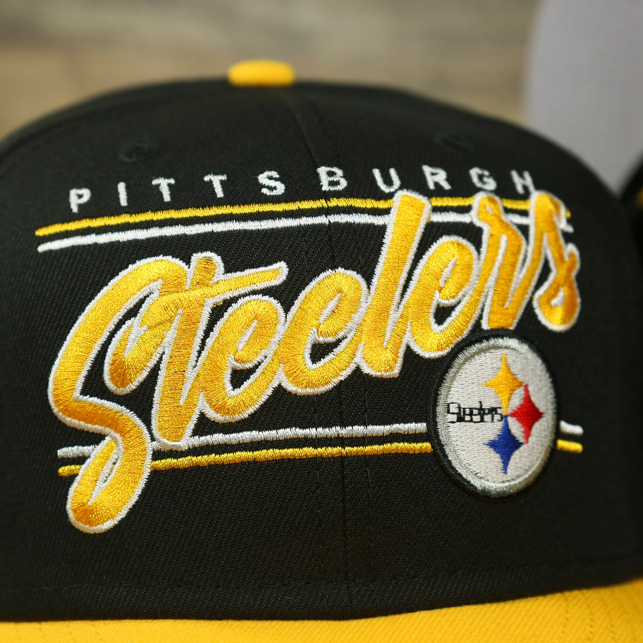steelers logo on the Pittsburgh Steelers "Team Script" College Bar 9Fifty Snapback Hat | Black/Yellow Steelers 950 Snap Cap