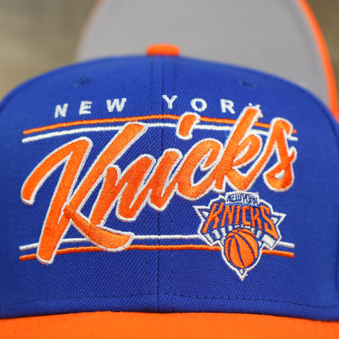 knicks logo on the New York Knicks "Team Script" College Bar Grey Bottom 9Fifty Snapback | Blue/Orange Knicks 950 Snap Cap