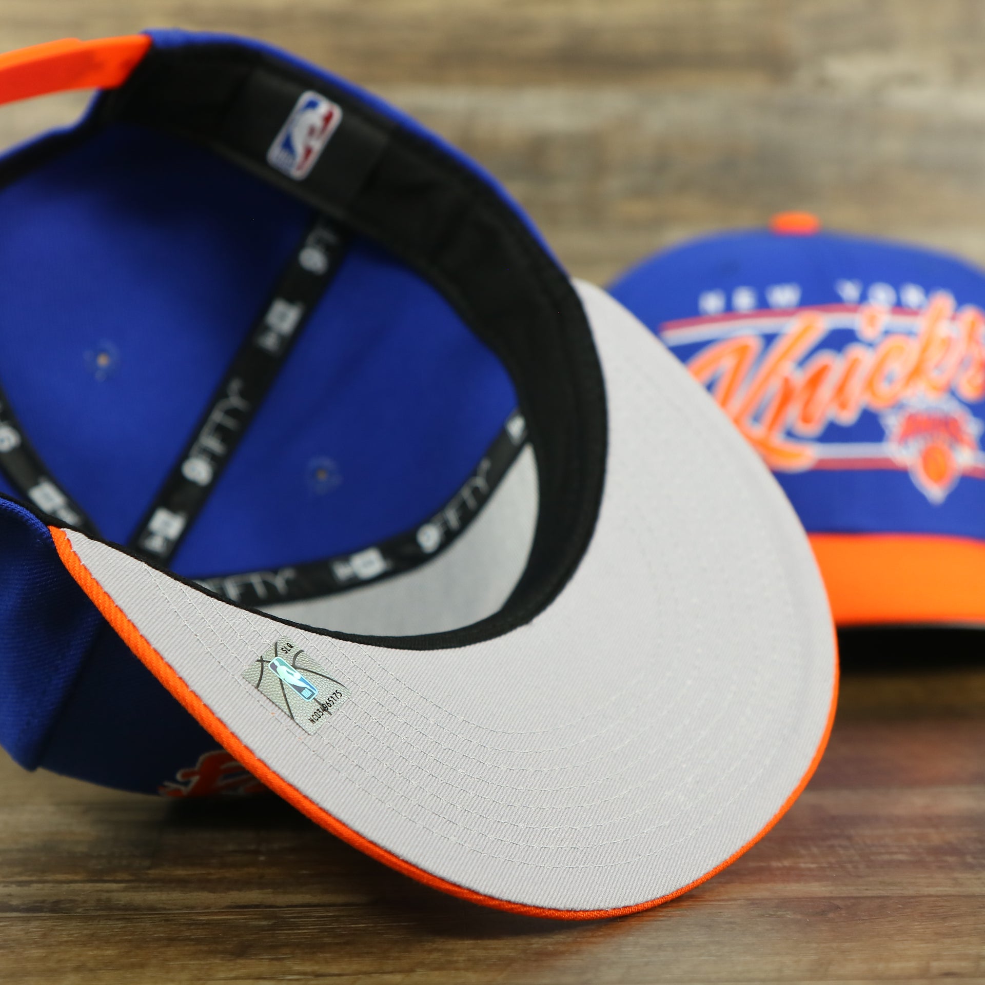 gray under visor of the New York Knicks "Team Script" College Bar Grey Bottom 9Fifty Snapback | Blue/Orange Knicks 950 Snap Cap