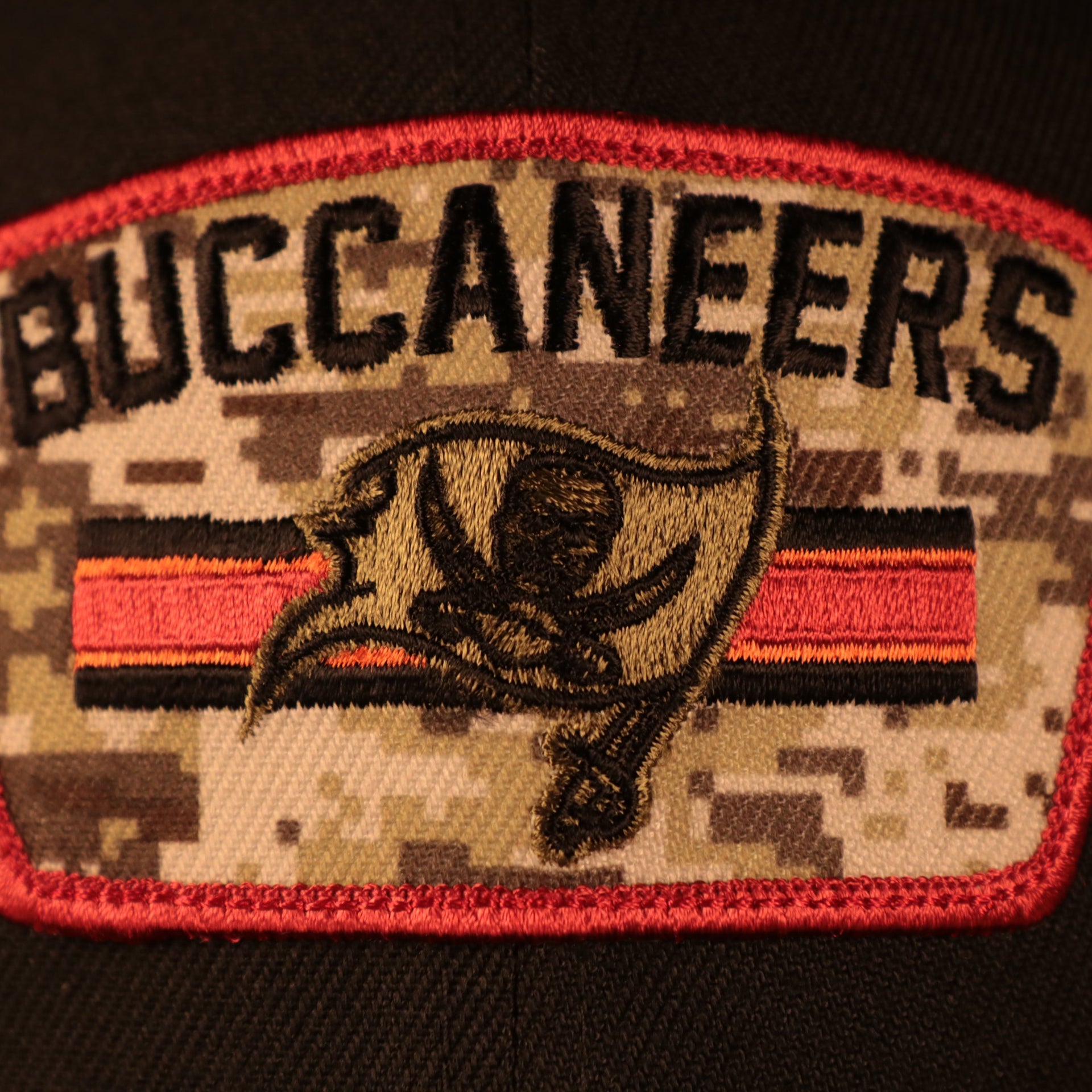 Close up of the front patch logo on the Tampa Bay Buccaneers 2021 Salute To Service On Field Sideline 9Fifty Snapback Trucker Hat