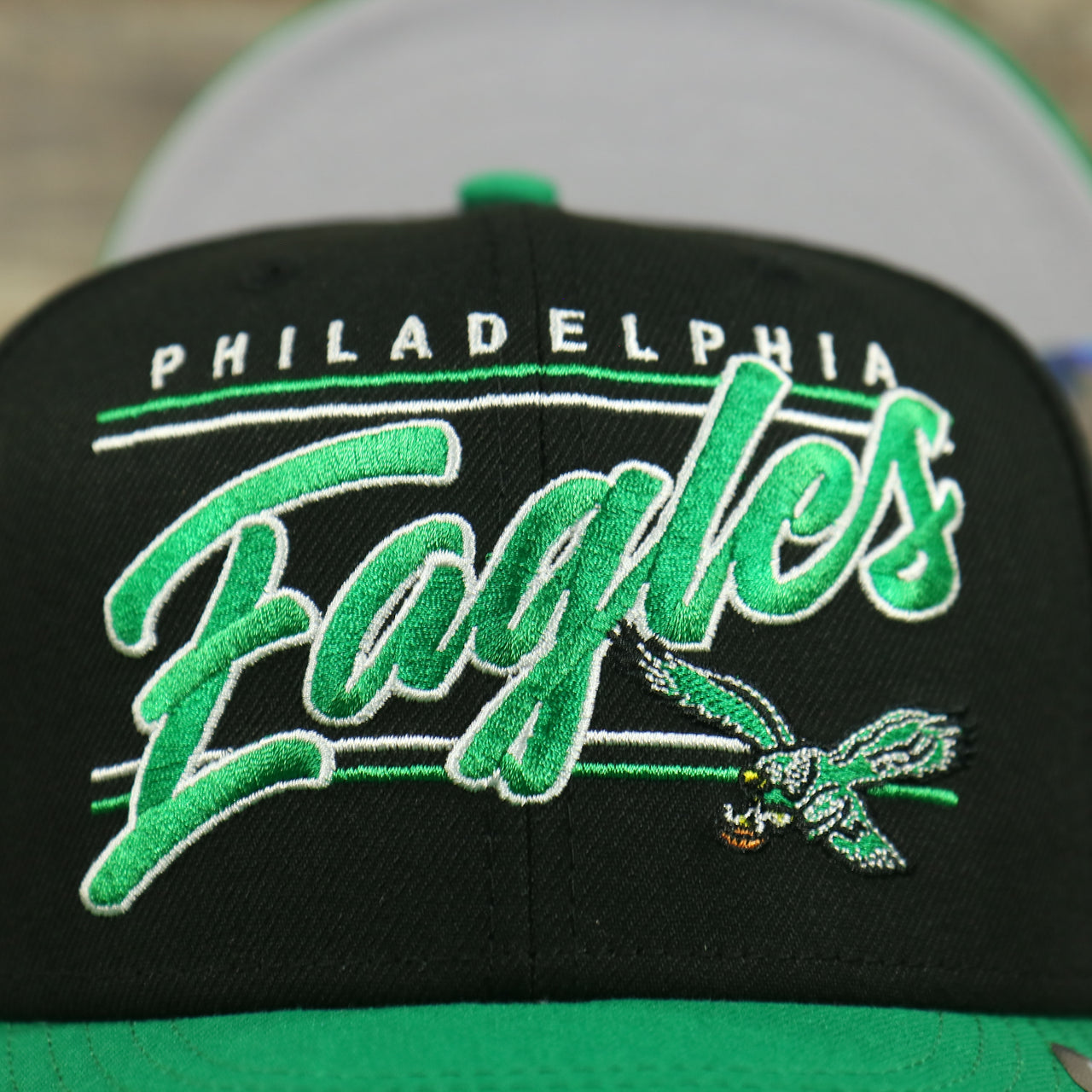 eagles logo on the Philadelphia Eagles Vintage Team Script College Bar Gray Bottom 9Fifty Snapback | Black/Kelly Green Birds 950 Snap Cap