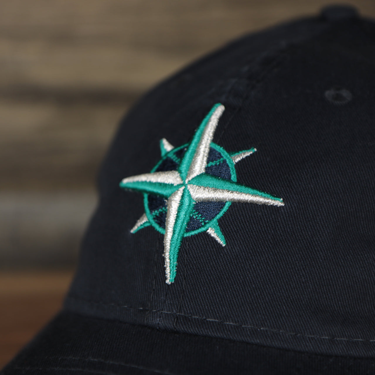Close up of the Mariners logo on the front of the Seattle Mariners 2022 MLB Batting Practice 9Twenty Trucker Dad Hat