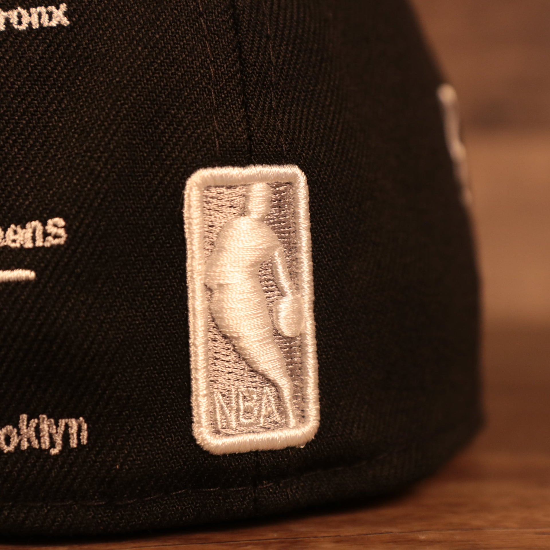 Close up of the NBA logo on the Brooklyn Nets City Transit All Over Side Patch Gray Bottom 59Fifty Fitted Cap