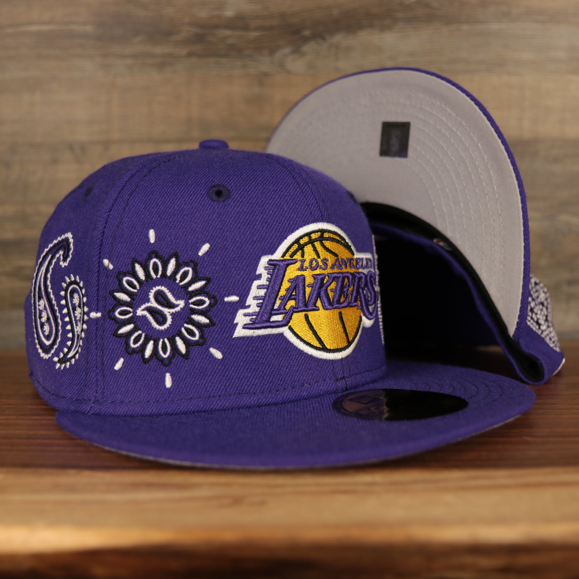 front and bottom of the Los Angeles Lakers All Over Paisley Bandana Pattern Grey Bottom 5950 Fitted Cap | Purple