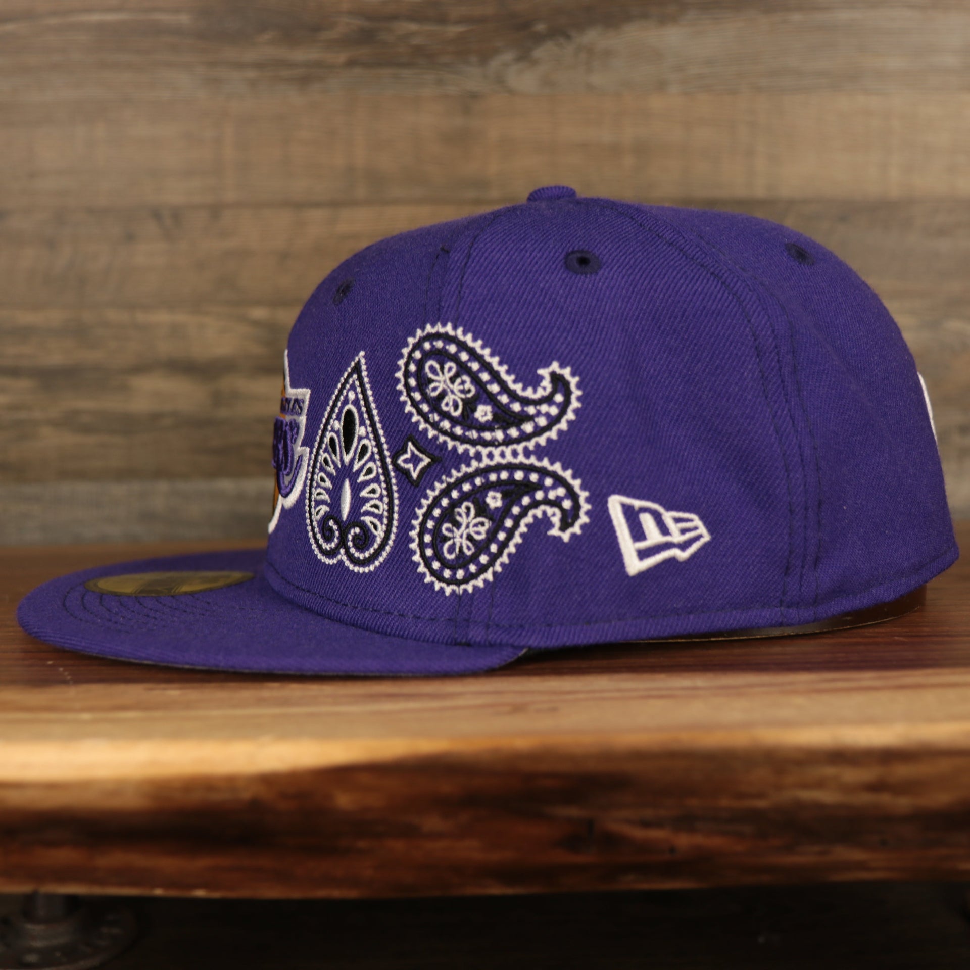 wearers left side of the Los Angeles Lakers All Over Paisley Bandana Pattern Grey Bottom 5950 Fitted Cap | Purple
