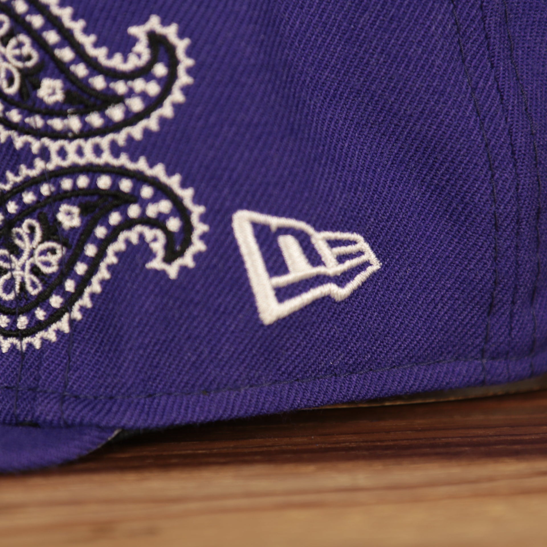 new era logo on the Los Angeles Lakers All Over Paisley Bandana Pattern Grey Bottom 5950 Fitted Cap | Purple