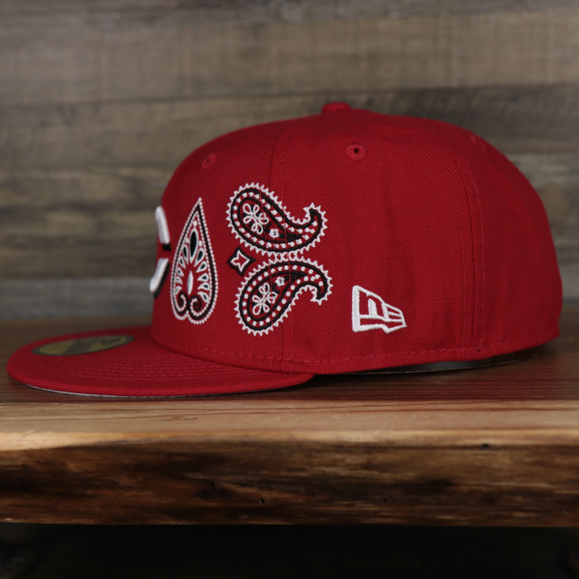wearers left side of the Cincinnati Reds All Over Paisley Bandana Pattern Grey Bottom 5950 Fitted Cap | Red