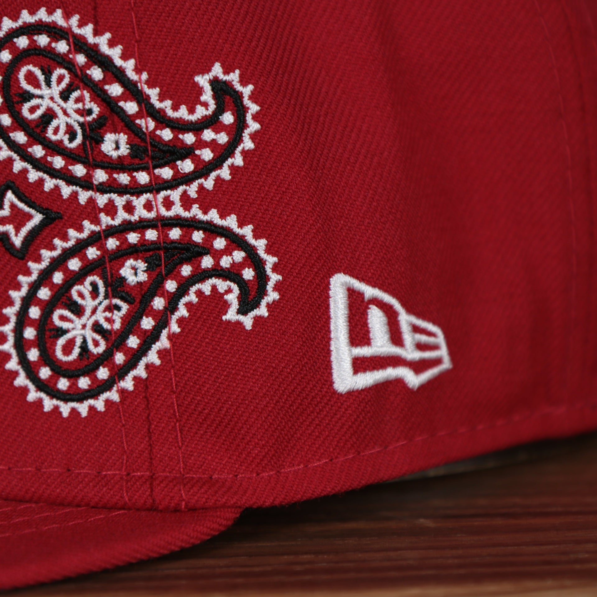 new era logo on the Cincinnati Reds All Over Paisley Bandana Pattern Grey Bottom 5950 Fitted Cap | Red