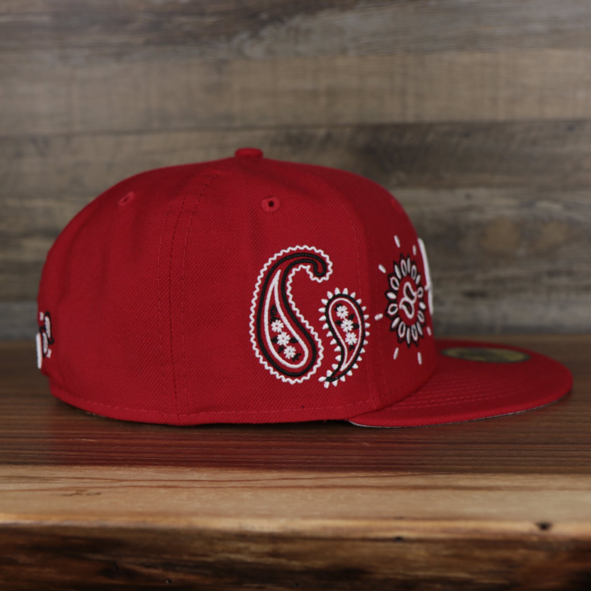 wearers right side of the Cincinnati Reds All Over Paisley Bandana Pattern Grey Bottom 5950 Fitted Cap | Red