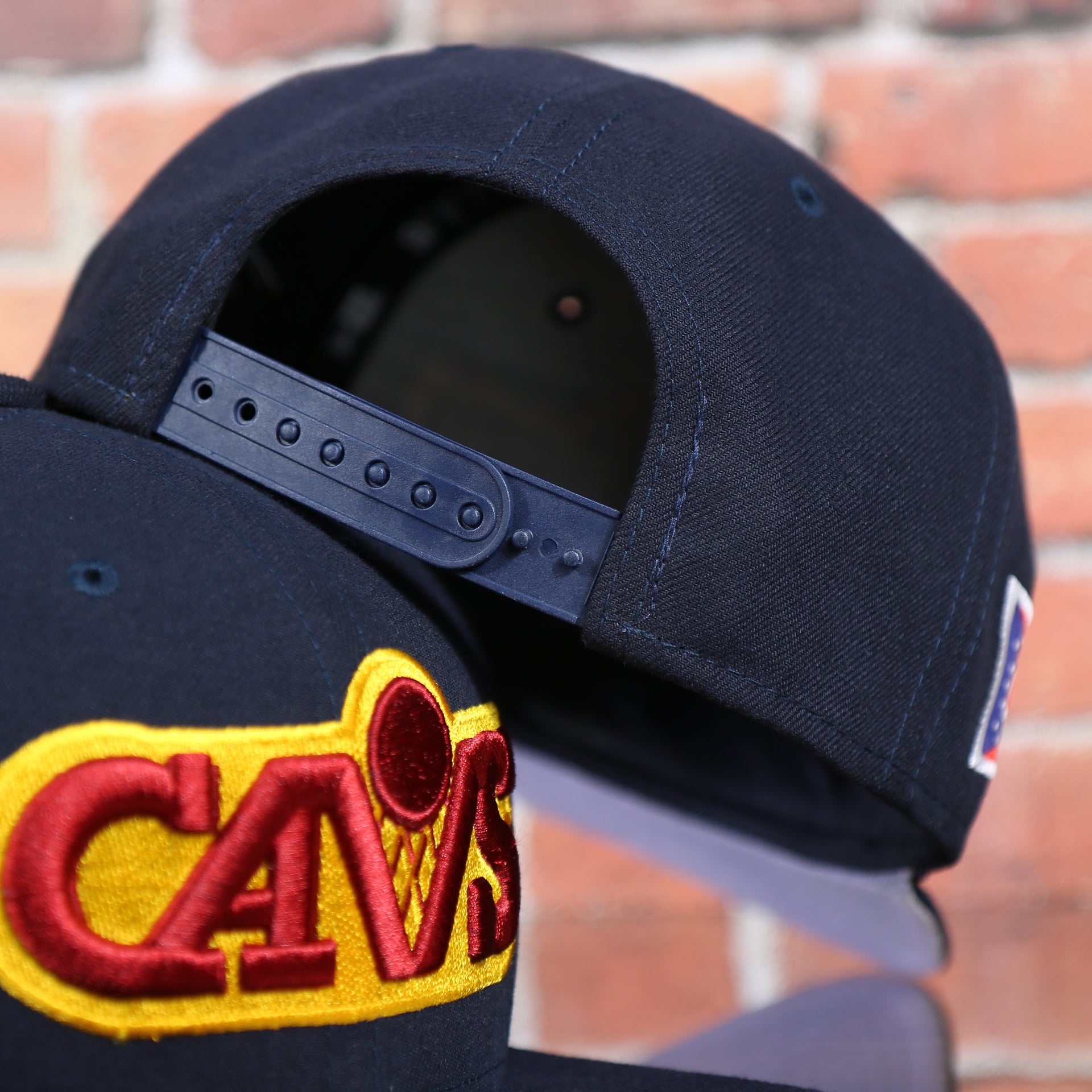 backside of the Cleveland Cavaliers Vintage City Flag Side Patch Gray Bottom 9Fifty Snapback | Navy