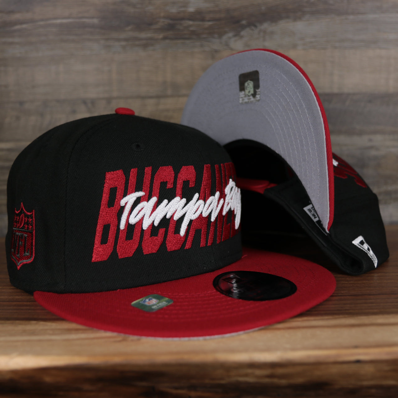 front of the Tampa Bay Buccaneers 2022 NFL Draft 9Fifty Grey Bottom On-Field Snapback | Black