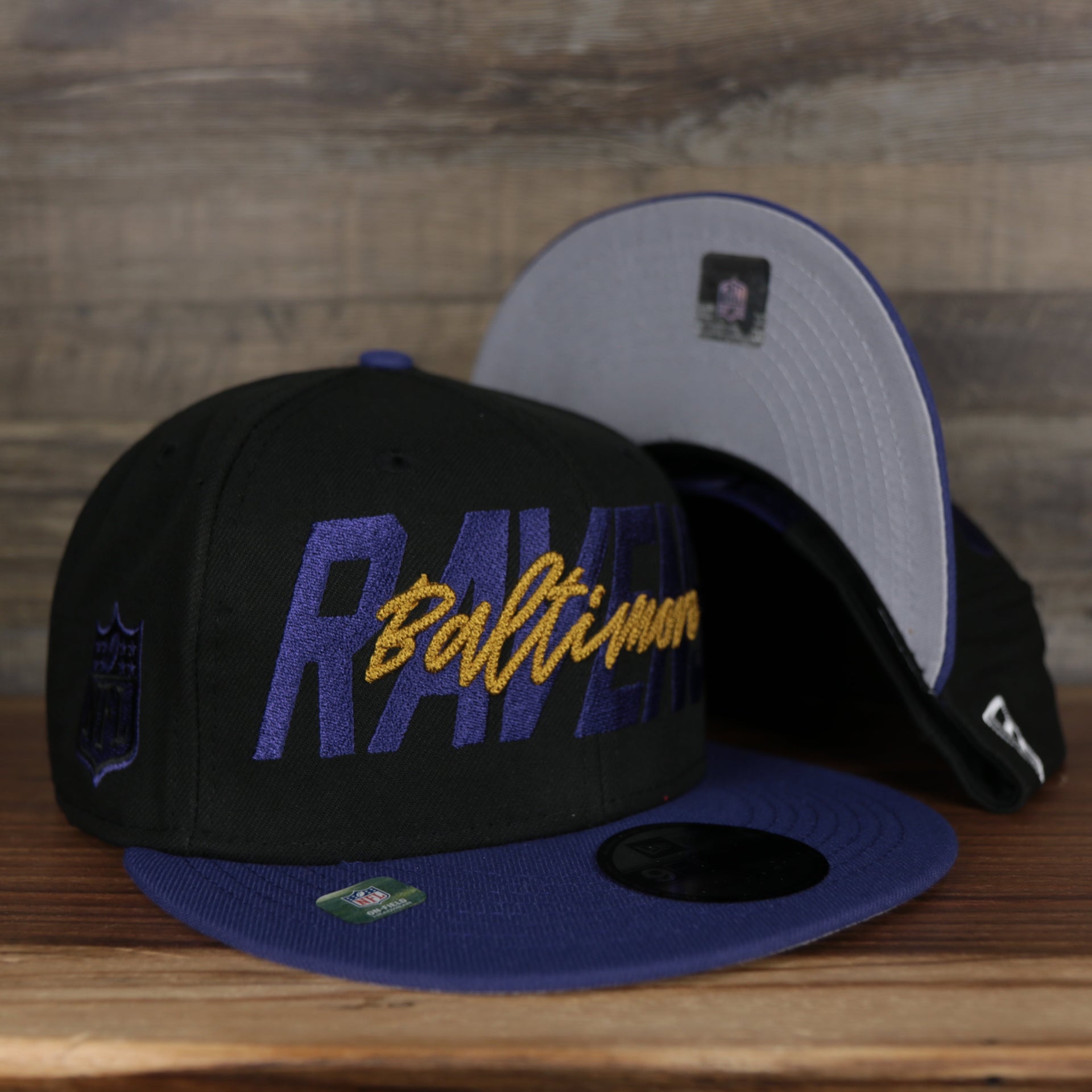 front and bottom of the Baltimore Ravens 2022 NFL Draft 9Fifty Grey Bottom On-Field Snapback | Black