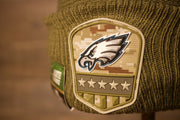 the eagles logo is on a shield which is made of this rubber like material and has a camo background Eagles Youth Beanie | Philadelphia Eagles 2019 Salute To Service Beanie