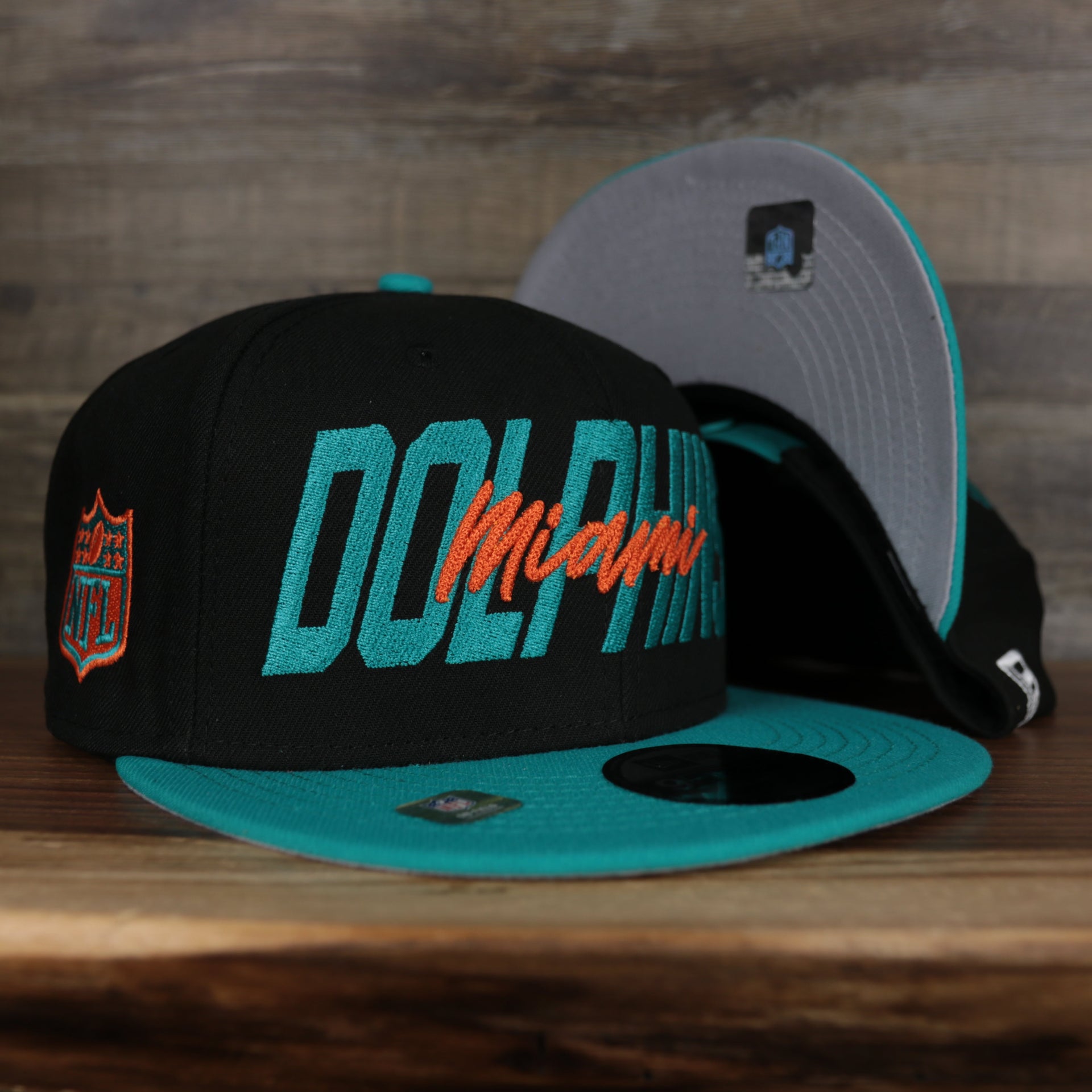 front and bottom of the Miami Dolphins 2022 NFL Draft 9Fifty Grey Bottom On-Field Snapback | Black