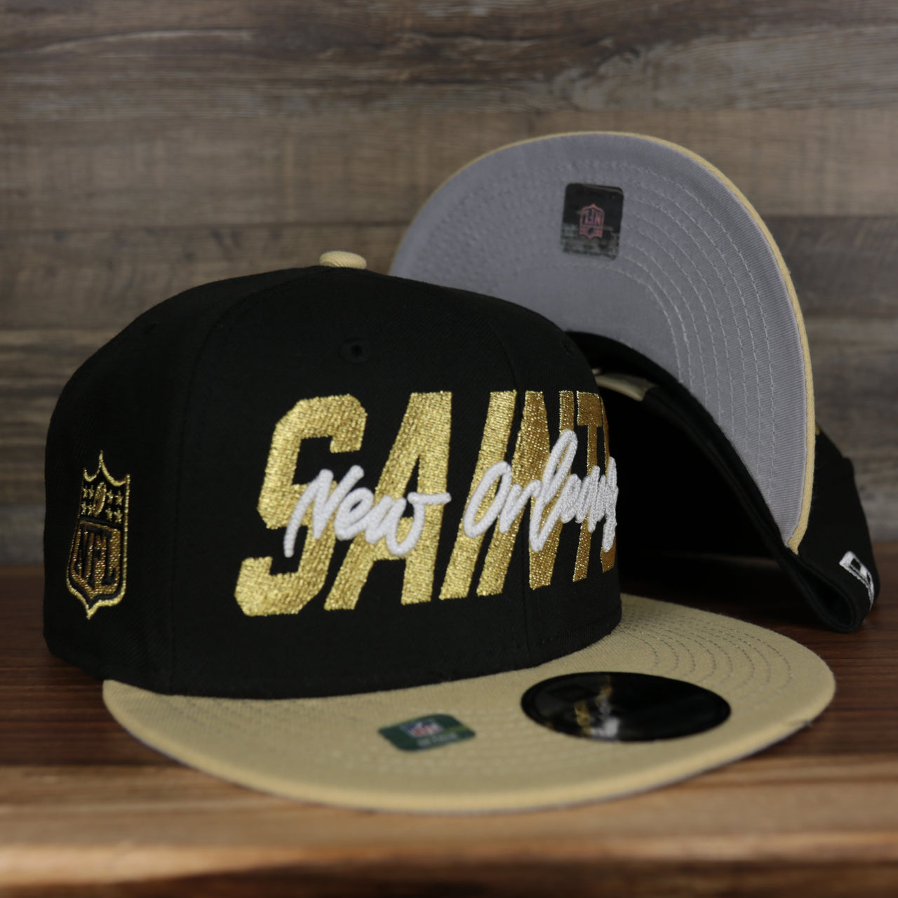 front and bottom of the New Orleans Saints 2022 NFL Draft 9Fifty Grey Bottom On-Field Snapback | Black