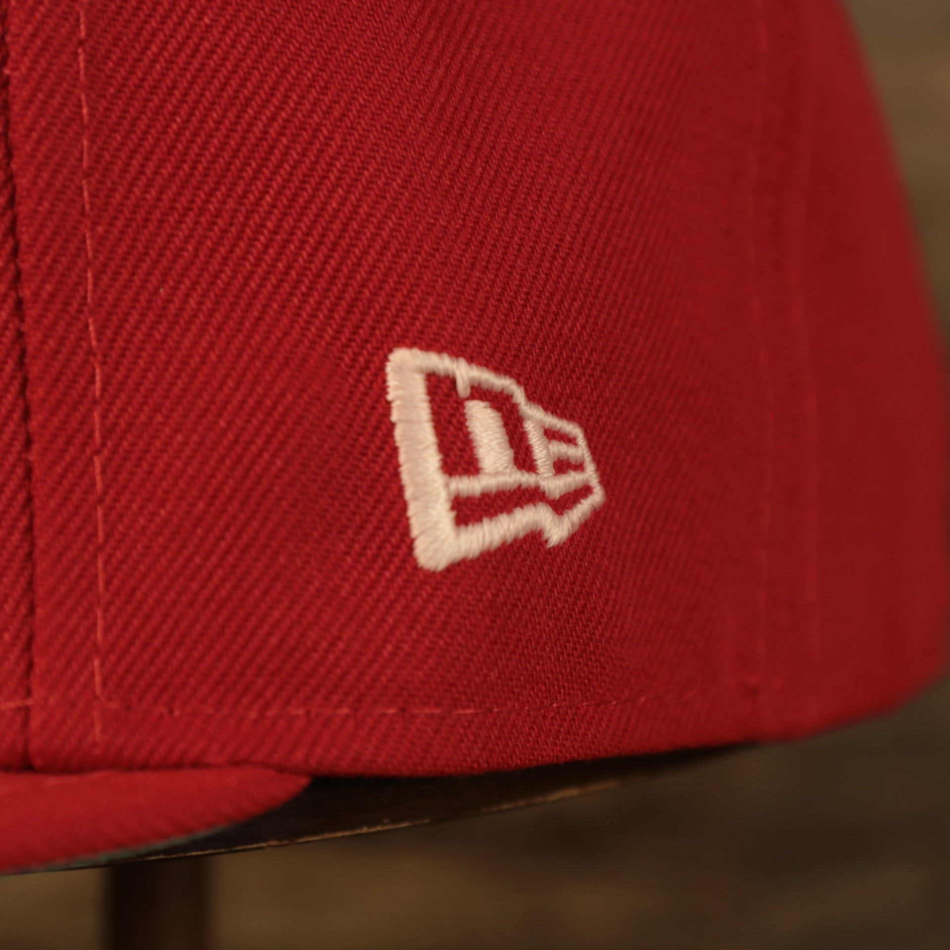 Close up of the New Era logo of Philadelphia Phillies Glow In The Dark 100th Anniversary Teal Bottom Side Patch 59Fifty Fitted Cap