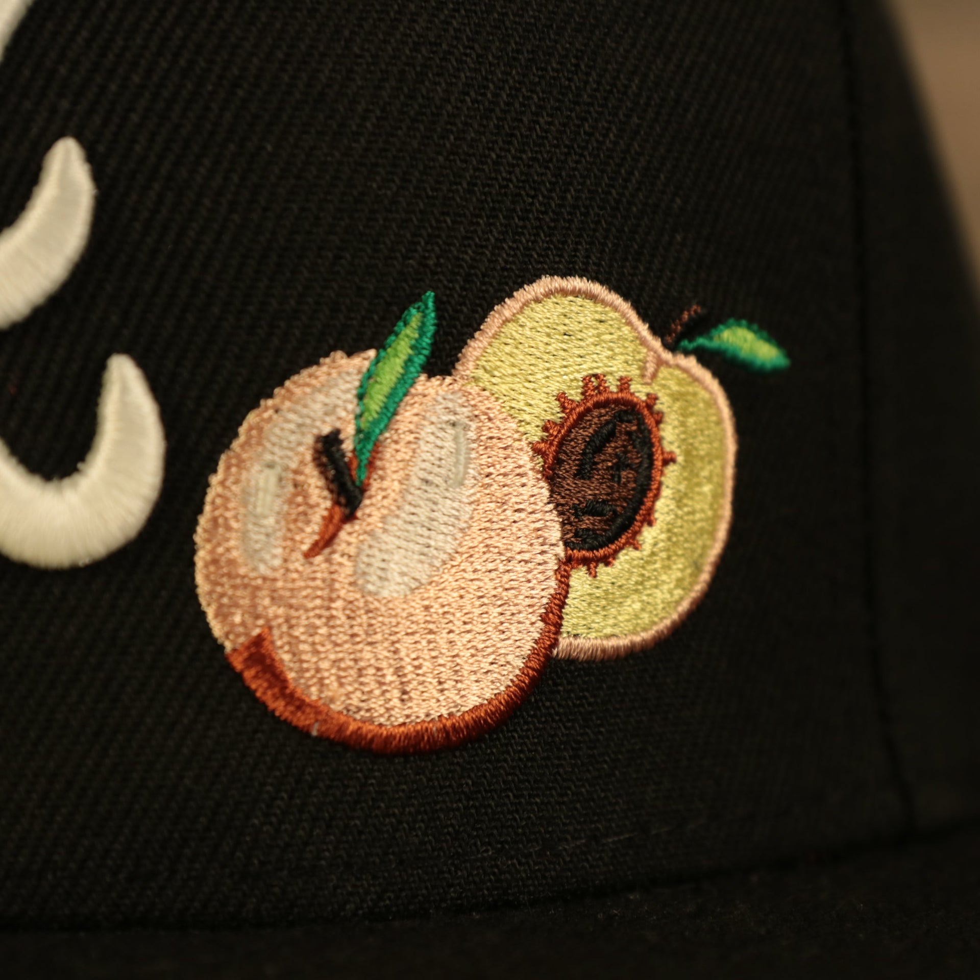 Close up of the Georgia peach patch on the Atlanta Braves Glow In The Dark 1995 World Series Peach Bottom 59Fifty Side Patch Fitted Cap