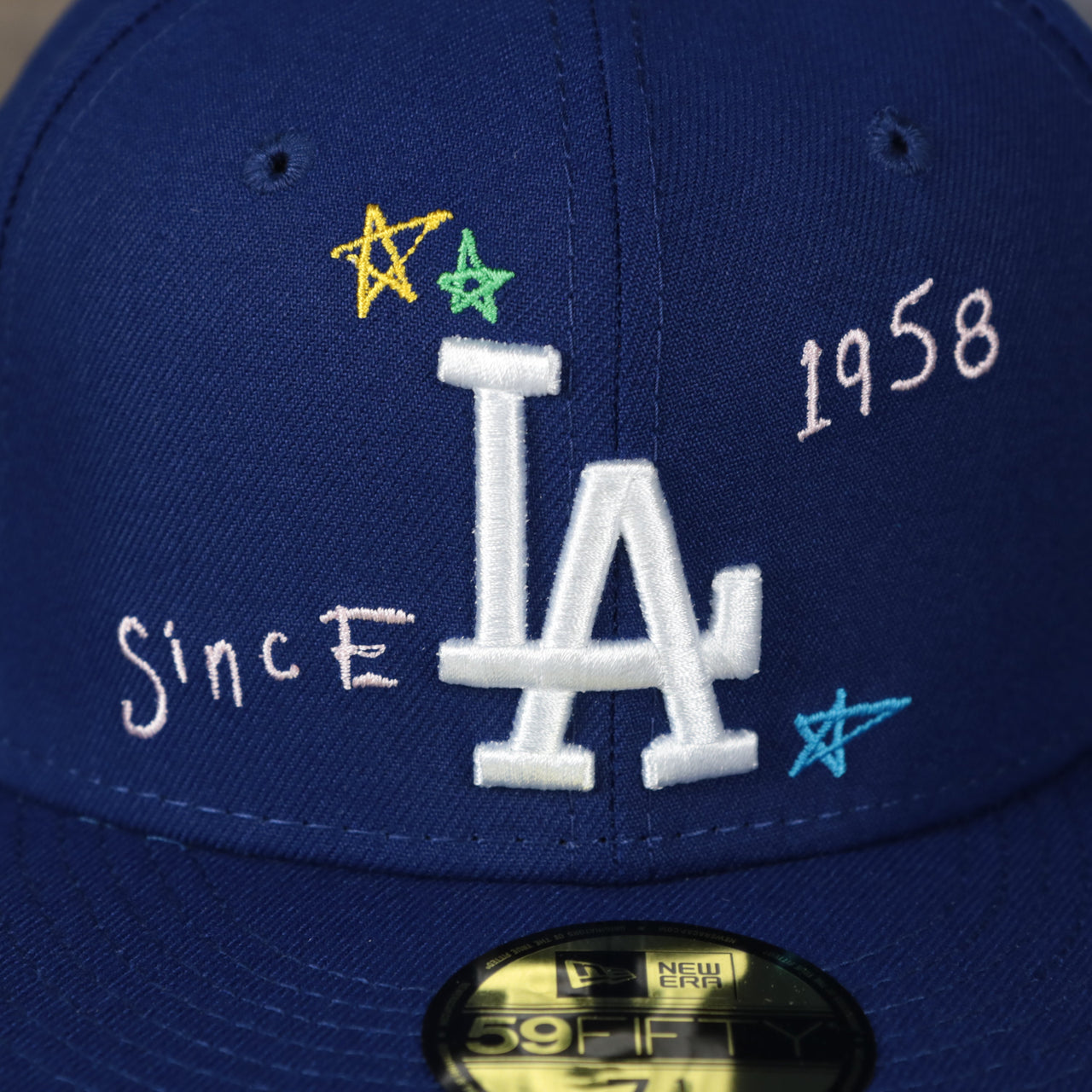 A close up of the Dodger logo on the Los Angeles Dodgers “Scribble” Side Patch Gray Bottom 59Fifty Fitted Cap
