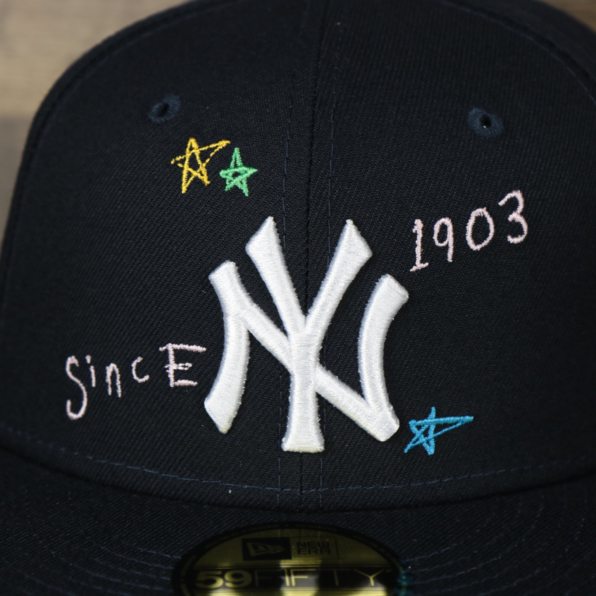 A close up of the Yankees logo on the New York Yankees “Scribble” Side Patch Gray Bottom 59Fifty Fitted Cap