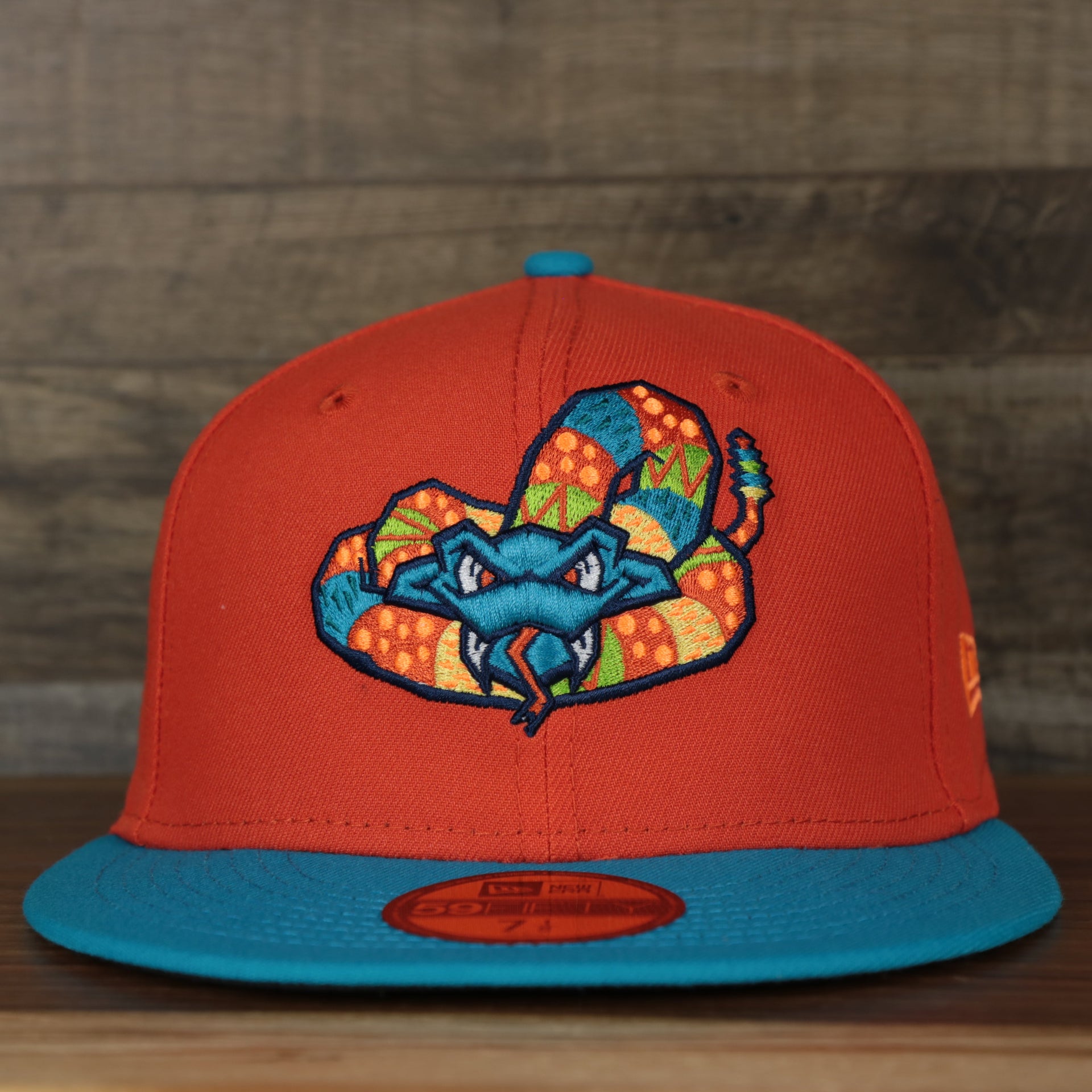 front view of the Wisconsin Timber Rattlers 2022 Cascabeles de Wisconsin Copa On-Field Black Bottom 5950 Fitted Cap | Orange