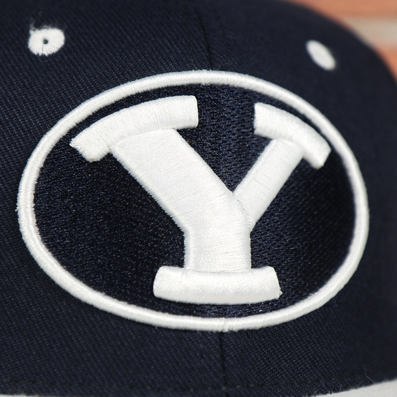 cougars logo on the BYU Cougars Green Bottom Arched Wordmark Snapback Cap | Navy Blue Snap Cap