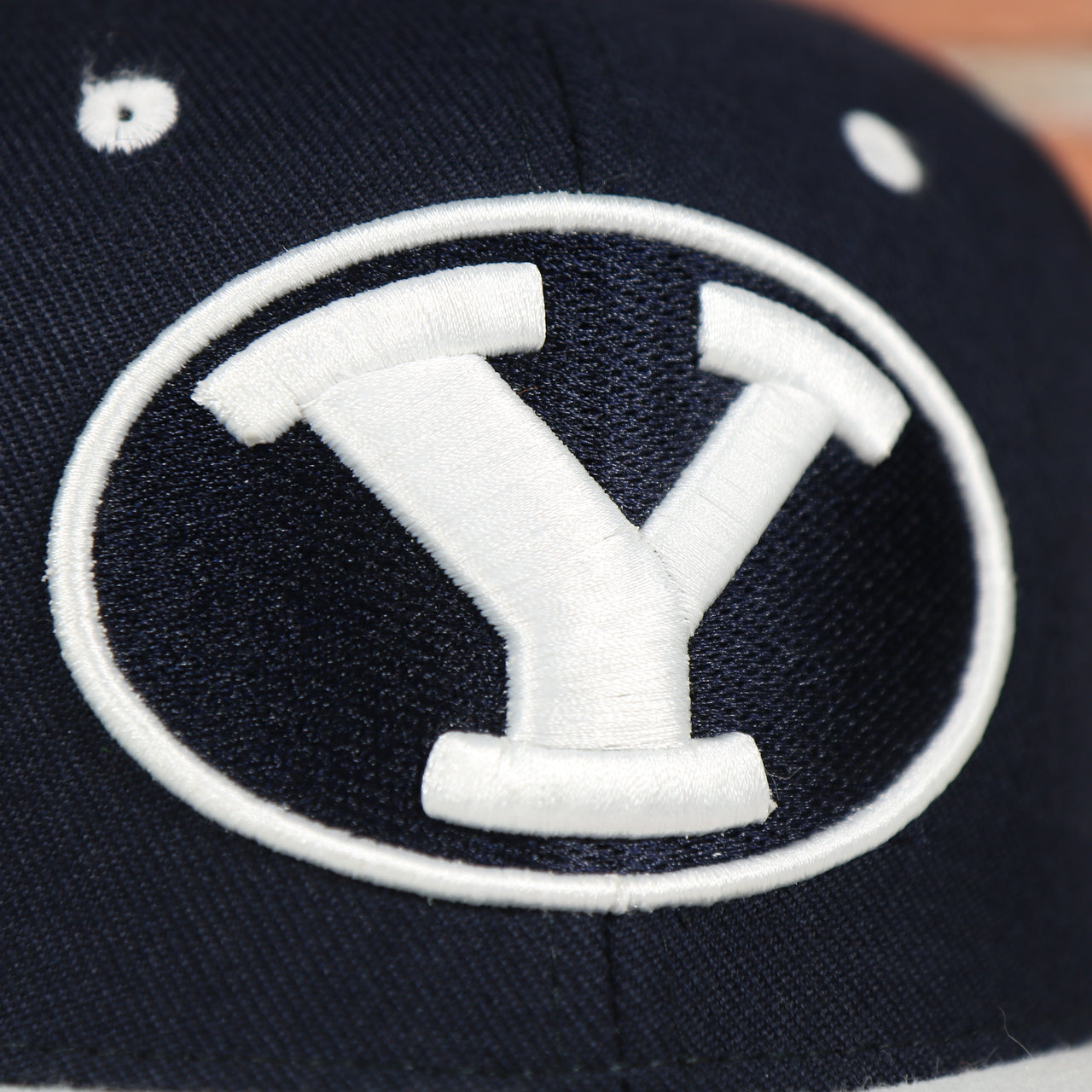 cougars logo on the BYU Cougars Green Bottom Arched Wordmark Snapback Cap | Navy Blue Snap Cap