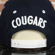 cougars wordmark on the BYU Cougars Green Bottom Arched Wordmark Snapback Cap | Navy Blue Snap Cap