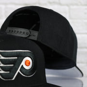 Back of the Philadelphia Flyers No Shot Grey Undervisor Black Snapback Hat