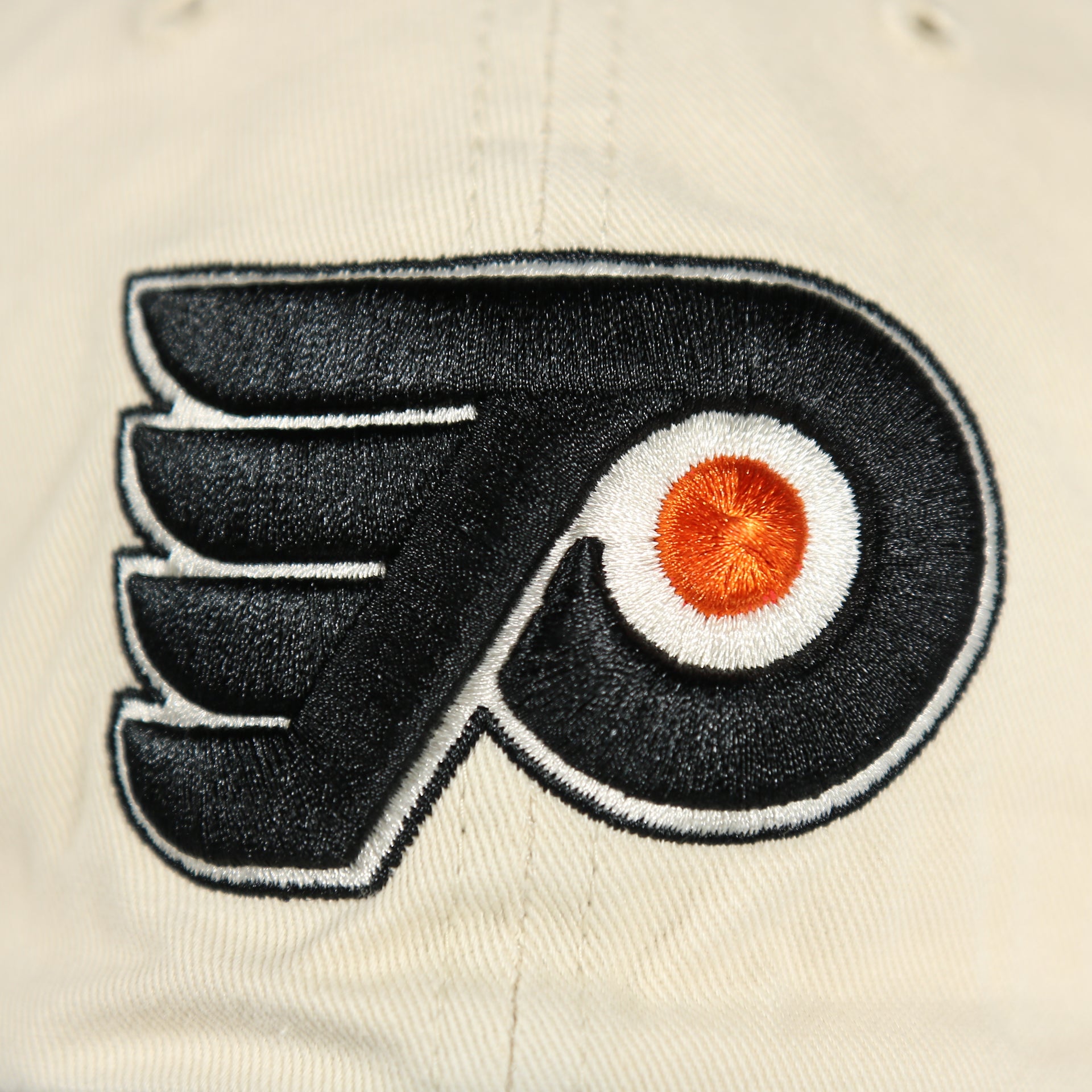 Close up of the Flyers logo on the front of the Philadelphia Flyers Natural Unstructured Crown Black Curved Brim Adjustable Dad Hat
