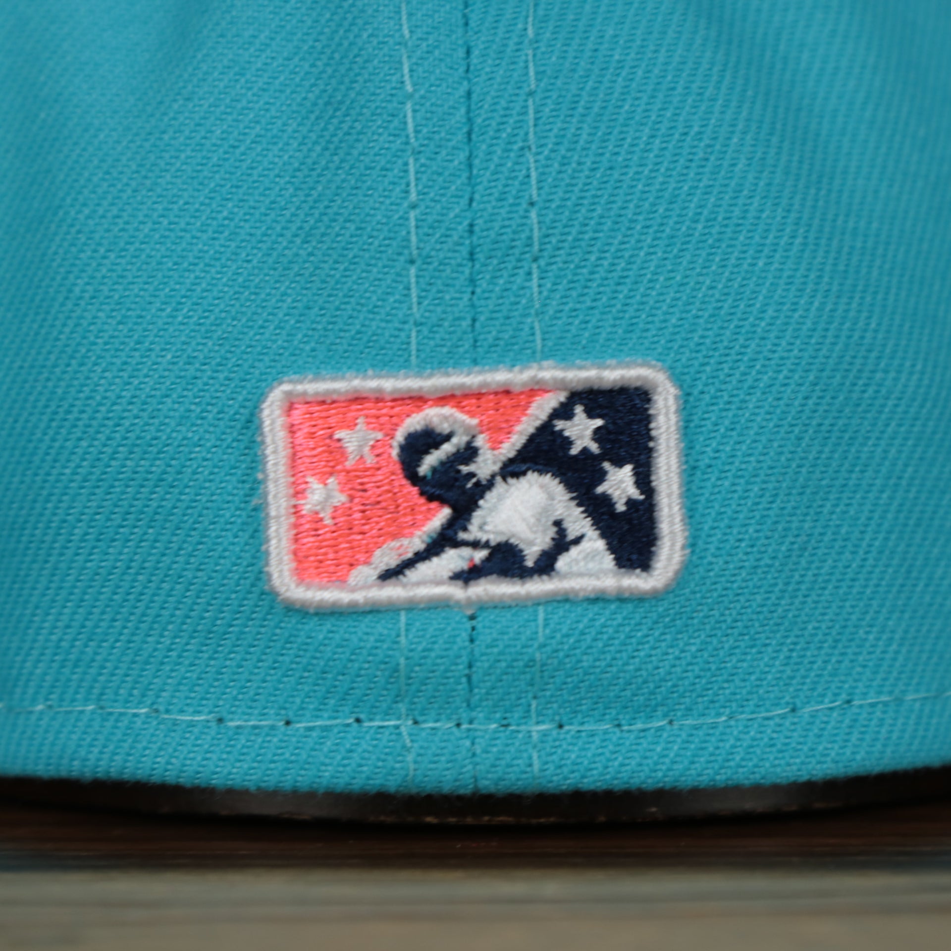 milb logo on the Leigh Valley Iron Pigs 2022 Coquis de Leigh Valley Copa de la Diversion On-Field Black Bottom 5950 Fitted Cap | Blue/Pink