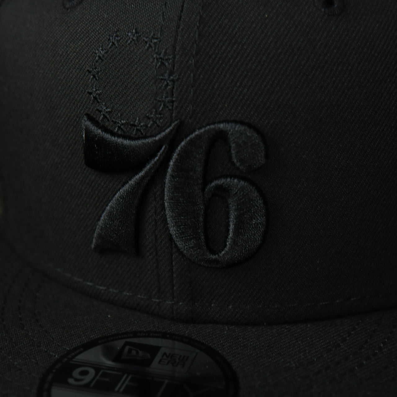 A close up of the logo on the Philadelphia 76ers New Era Tonal 9Fifty Snapback