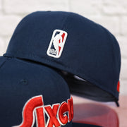 NBA logo on the back of the Philadelphia 76ers 2022 City Edition Sixers Script Spectrum Side Patch Navy 59Fifty Fitted Cap