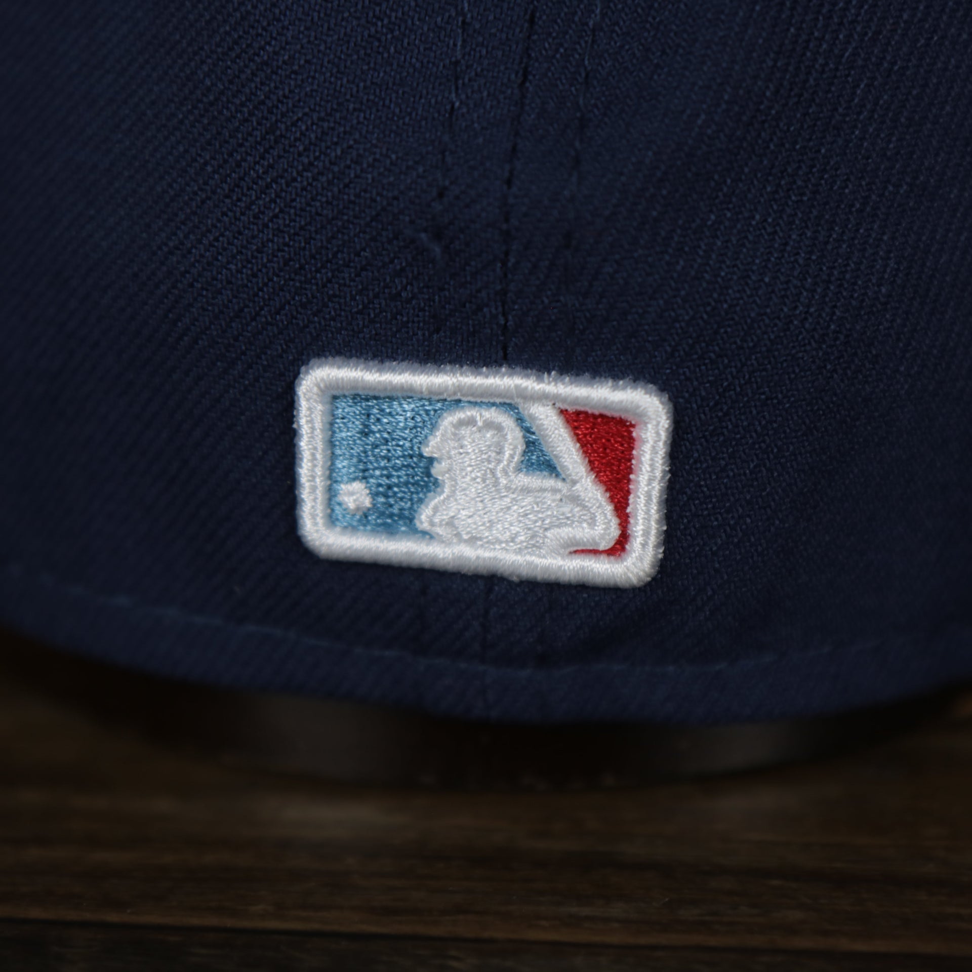 mlb logo on the Chicago Cubs MLB City Connect 2021 On-Field 59Fifty Black Bottom Fitted Hat | Navy Blue