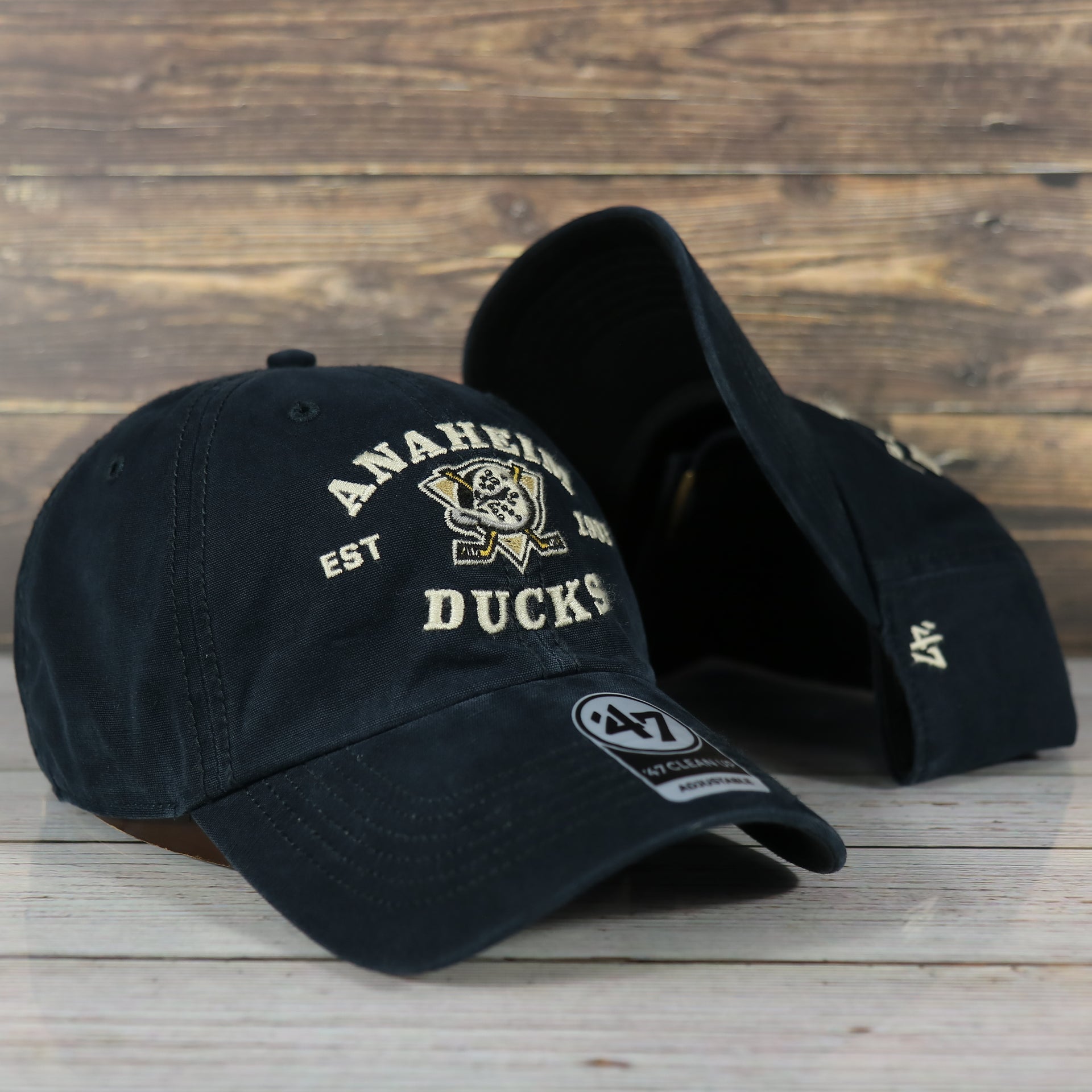 front and bottom of the Anaheim Ducks Throwback Distressed Black Dad Hat | Black Adjustable Baseball Cap