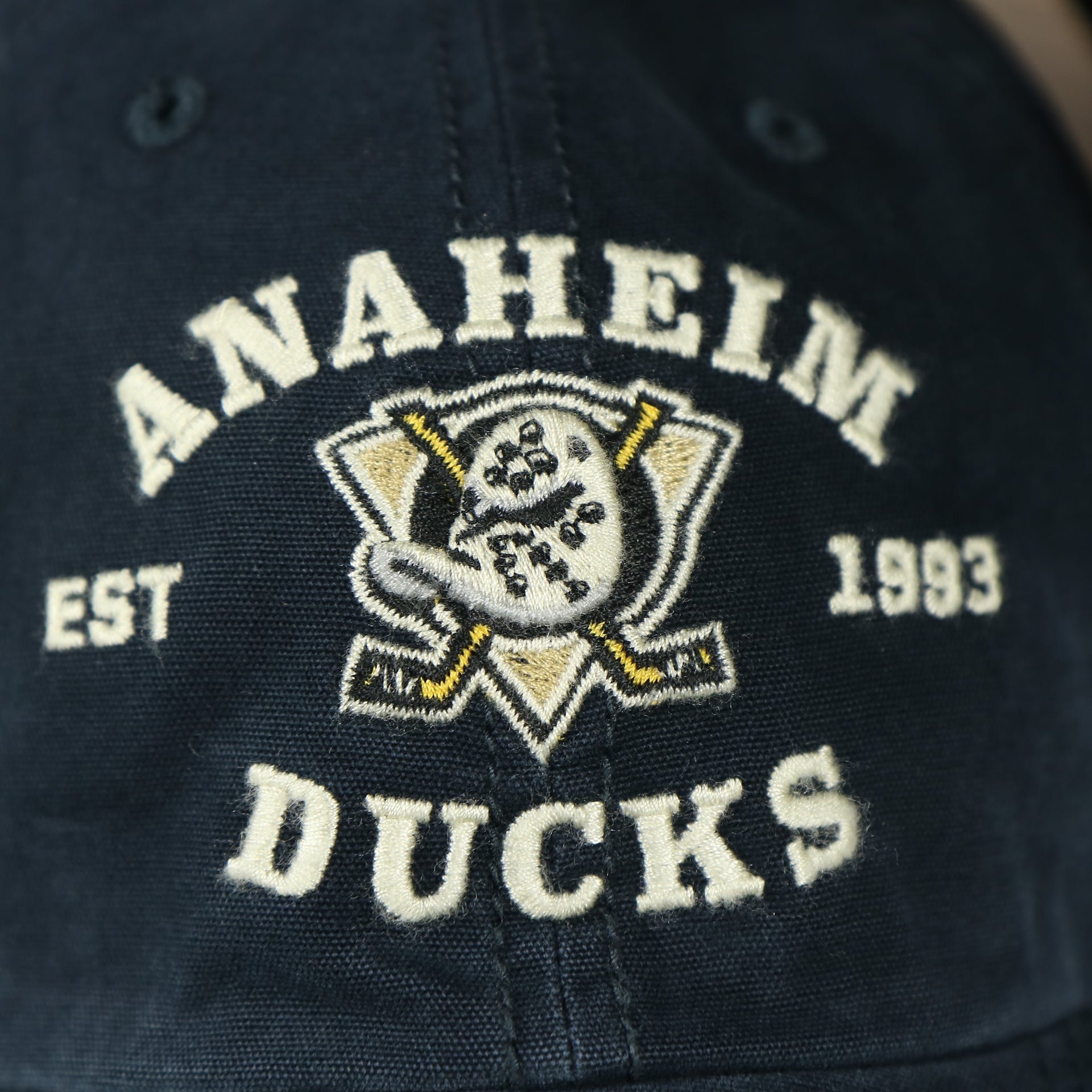 ducks logo on the front of the Anaheim Ducks Throwback Distressed Black Dad Hat | Black Adjustable Baseball Cap