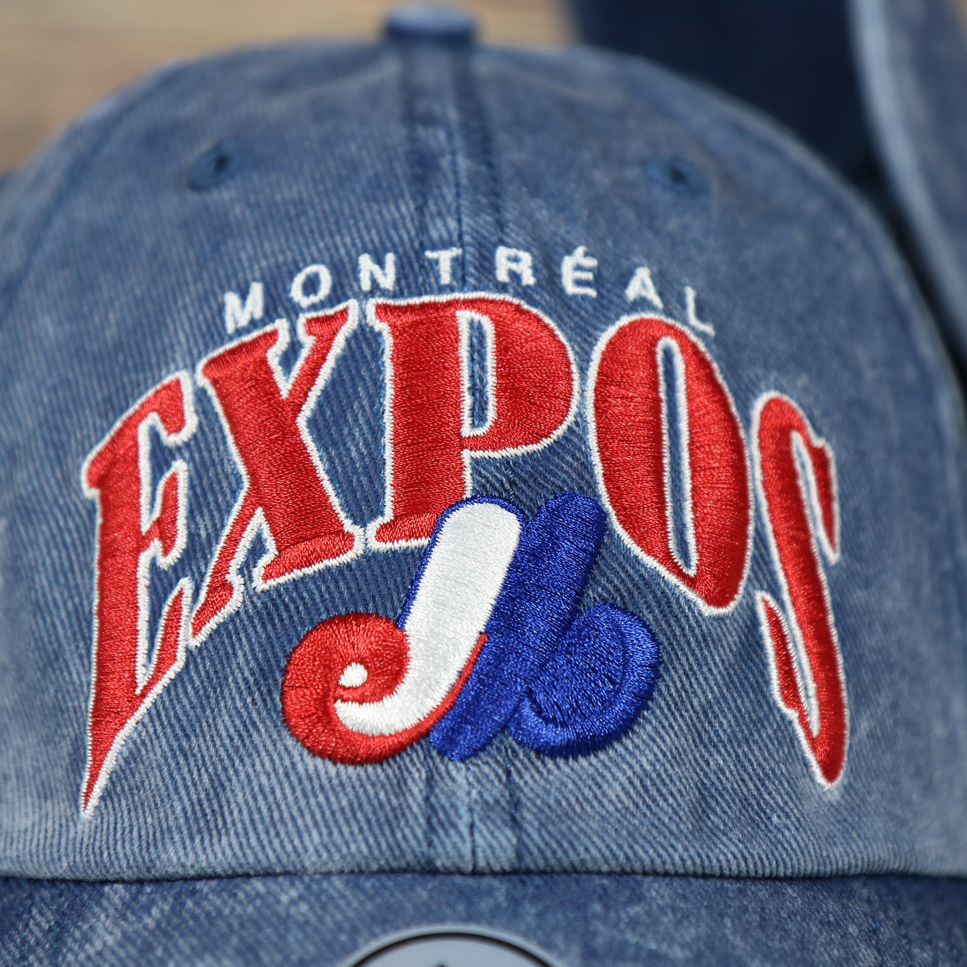 front logo on the Montreal Expos Throwback Distressed Blue Dad Hat | Blue Adjustable Baseball Cap