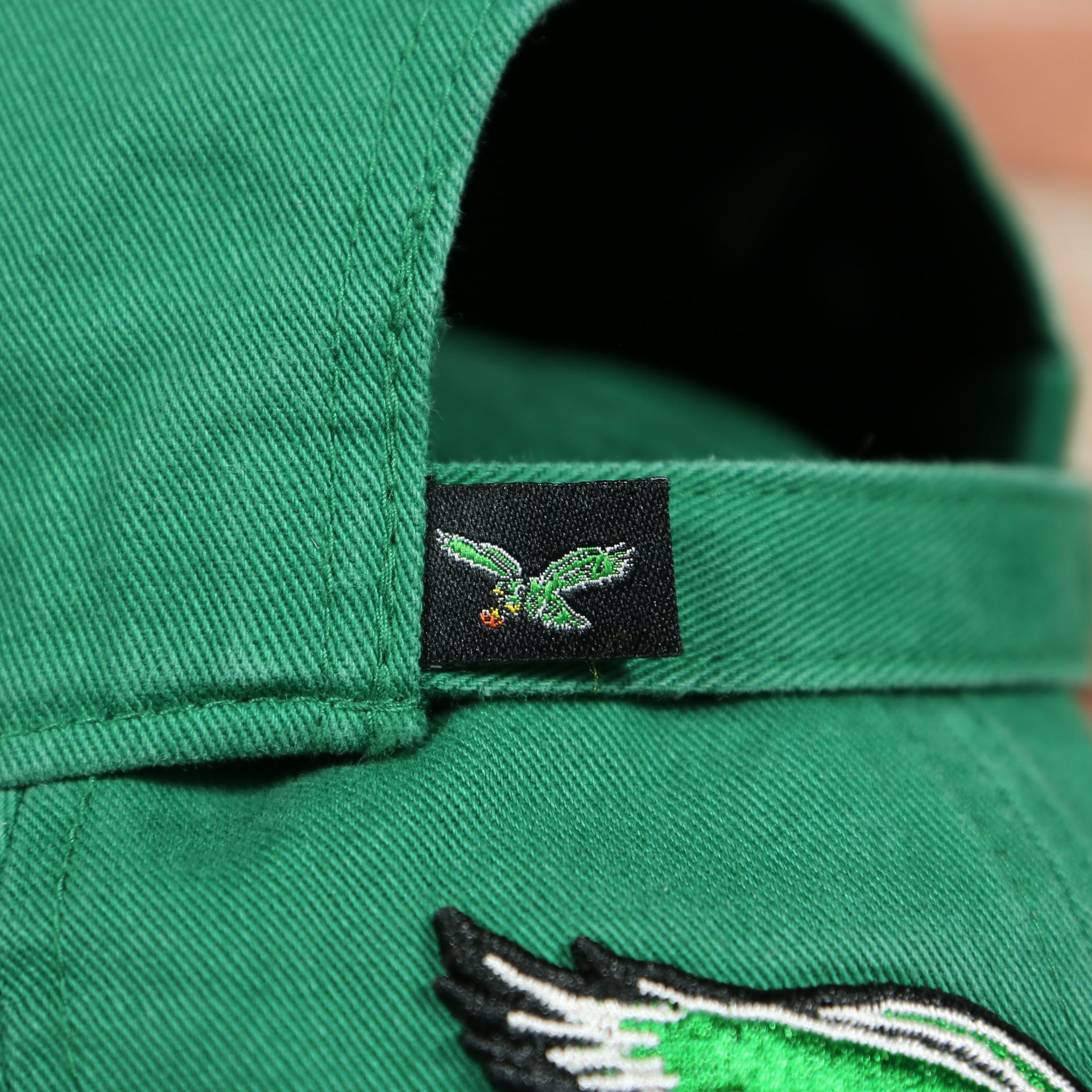 eagles tag on the backside of the Philadelphia Eagles Throwback Distressed White Dad Hat Hat | White Adjustable Baseball Cap