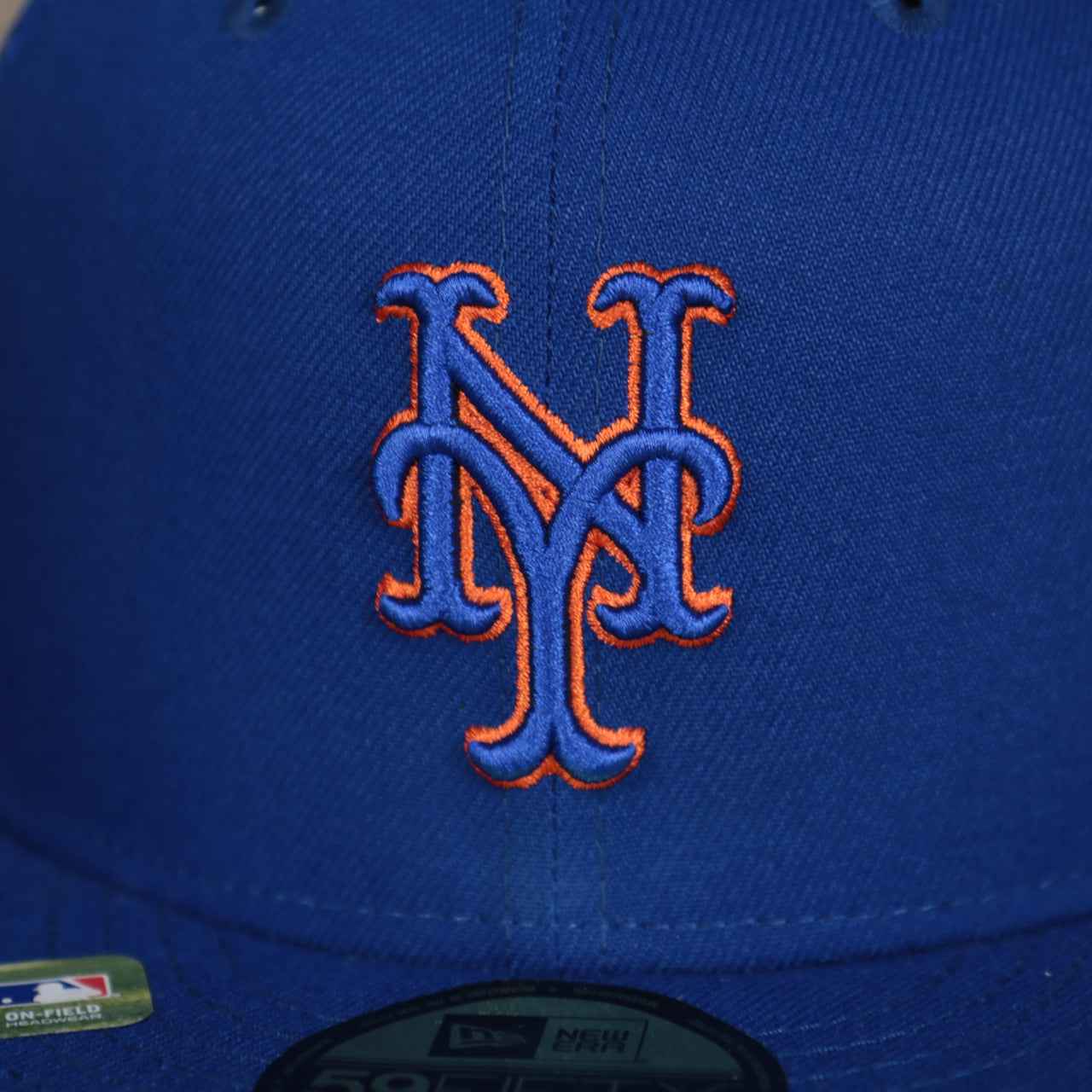 A close up of the Mets logo on the New York Mets Onfield 2022 Batting Practice 59Fifty Trucker Hat