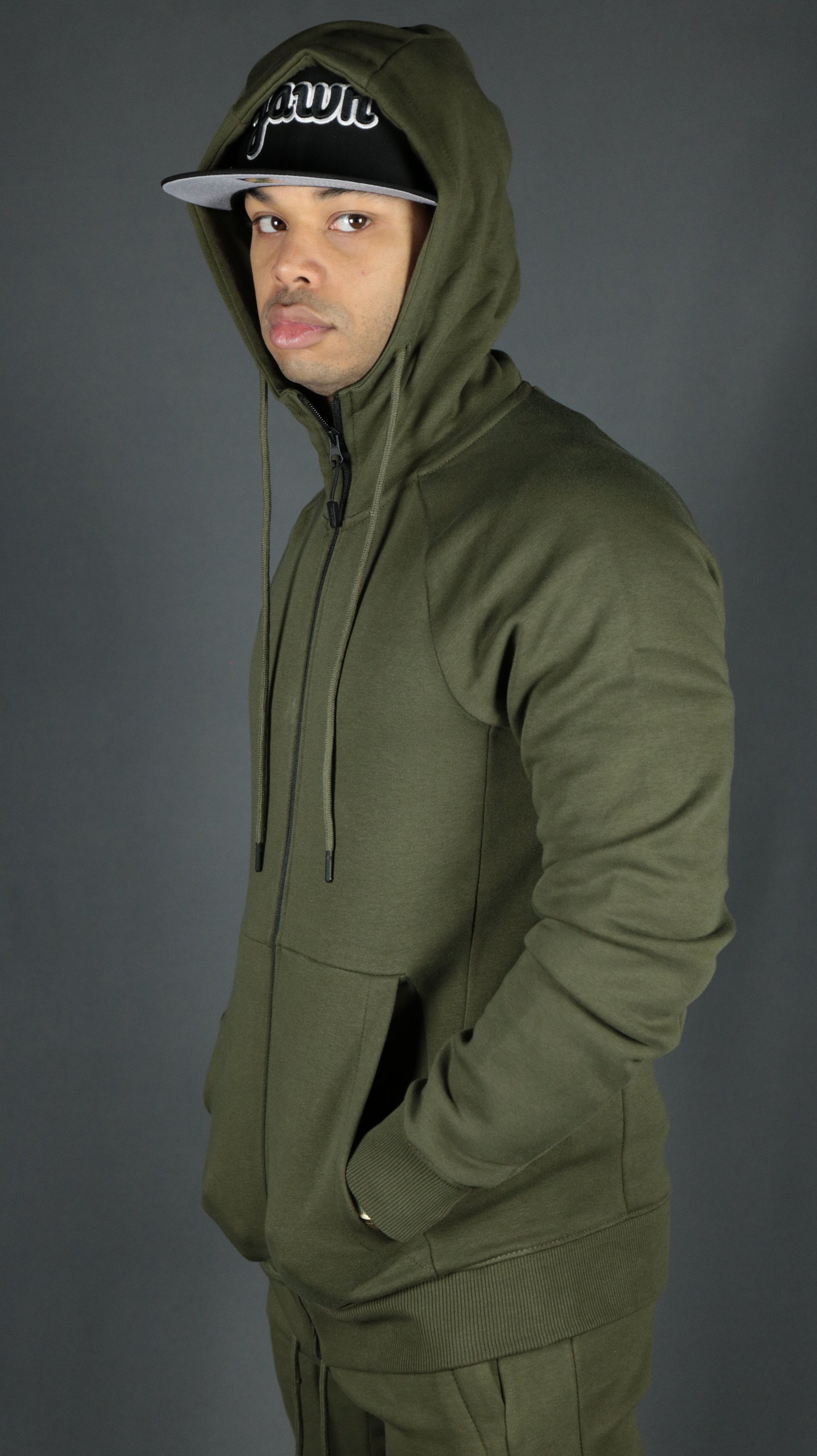 A model wearing the olive military green Jordan Craig zipup hoodie.