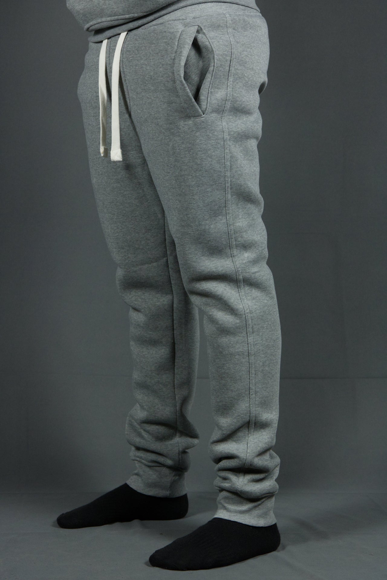 The bottom cuffs of these basic fleece heather grey sweatpants feature two spacious front pockets