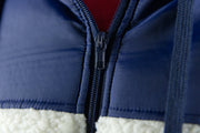 The zipper on the cream sherpa zip up hoodie is made out of a navy blue hard plastic